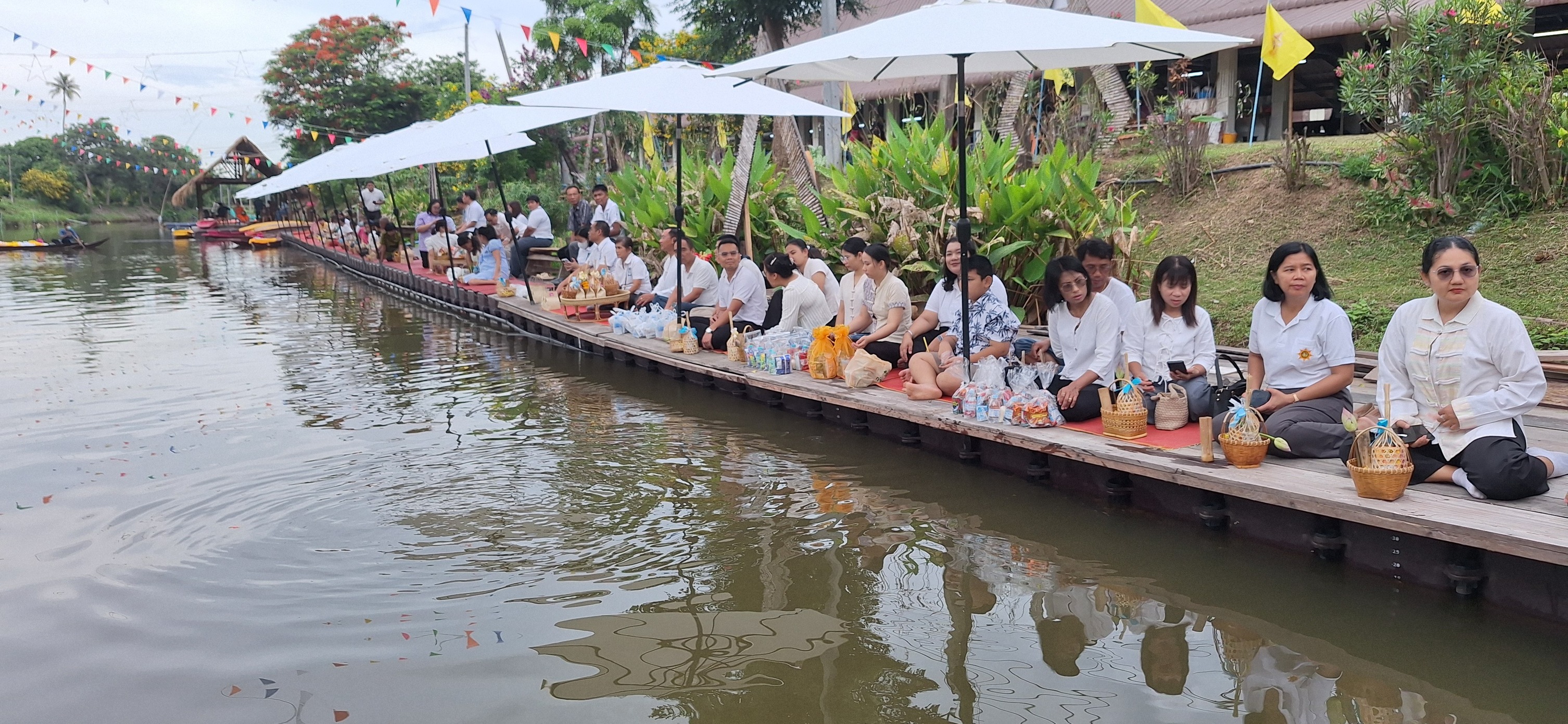 กิจกรรมตักบาตรทางน้ำและอุดหนุนสินค้าชุมชน “ตลาดชุมชนคุณธรรมดงกลางฯ”